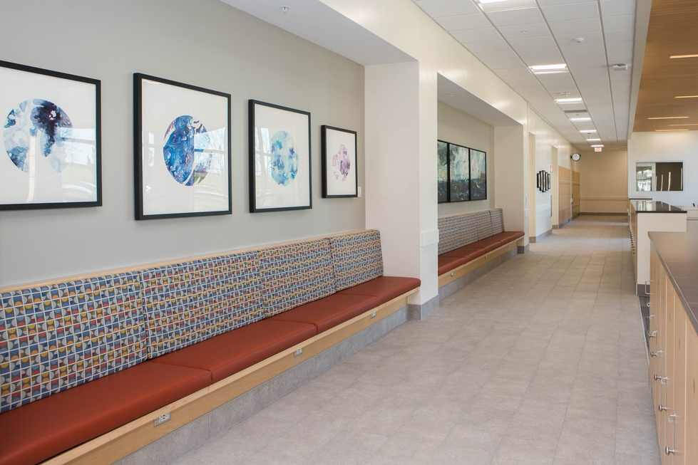 Photograph of a hallway in Finkelstein Hall that shows artwork on display above benches.